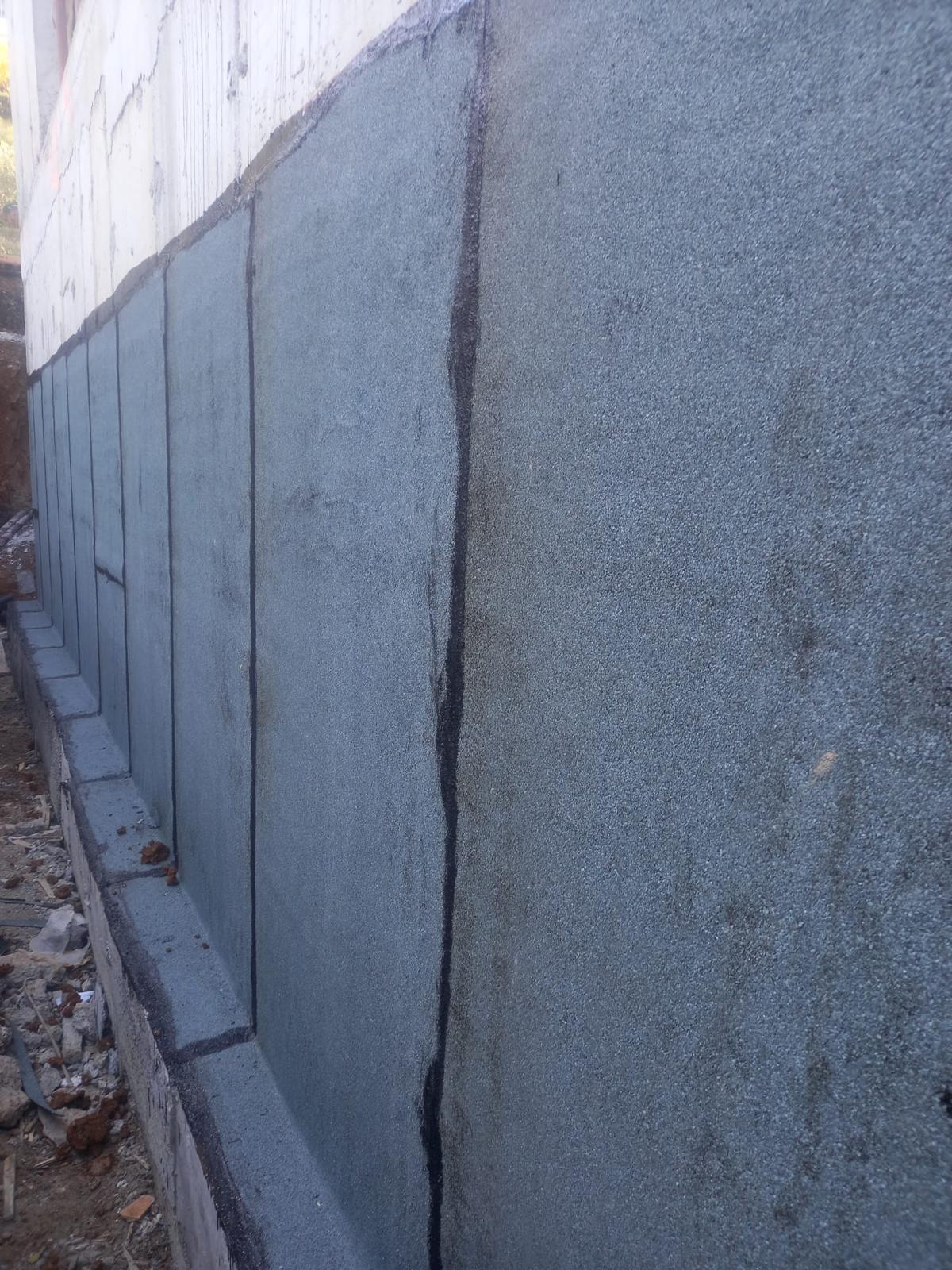 Nappe drainante posée contre l'étanchéité du mur enterré