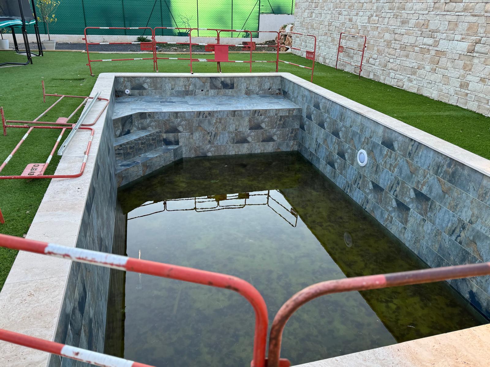 Détail bassin de piscine, carrelage pierre veinée et margelles pierre